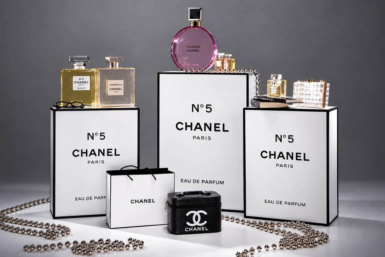CHANEL Белые подиумы CHANEL с флаконами, сумками и аксессуарами на сером фоне